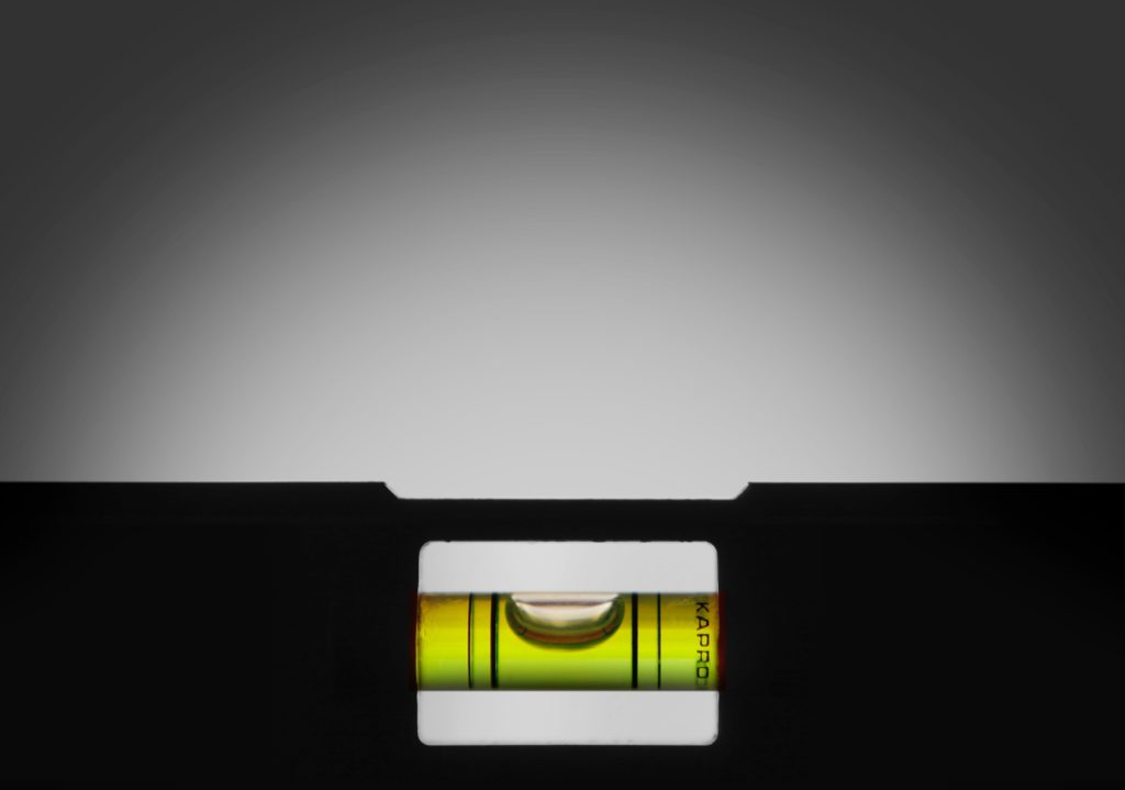 A close up of a measuring level with its bubble in the center, denoting a level surface.