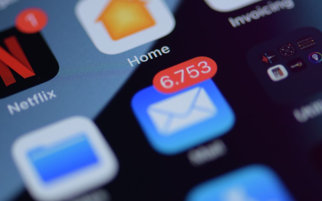 Close up of mobile phone screen with email icon showing notifications of new emails.